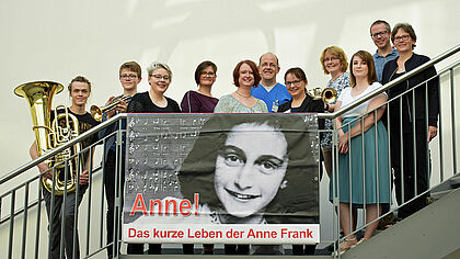Ein kleiner Teil der Aufführenden: Mitwirkende des Projektchores der Krankenpflegeschule sowie Bläser des „b-teams“ freuen sich auf die Aufführung von „Anne! Damit wir klug werden“.