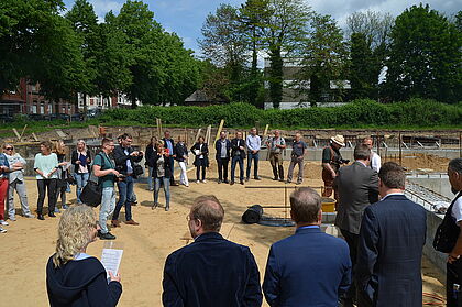 Menschen bei der Grundsteinlegung