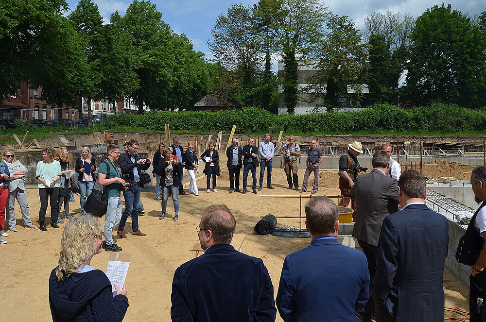 Menschen bei der Grundsteinlegung