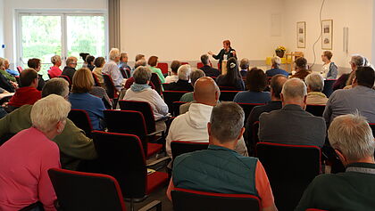 Menschen im Saal vor einer Rednerin