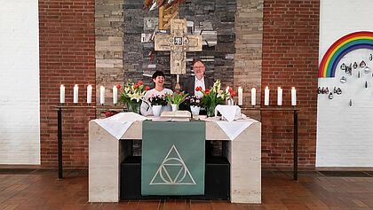 Pastorin Otto-Kempermann und Pastor Clausen unter dem Bronze-Kreuz, Dreifaltigkeitskirche Hohenlockstedt