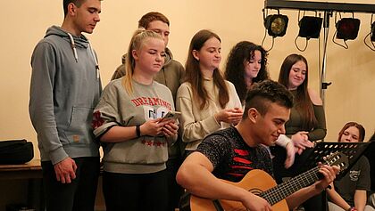Sieben junge Menschen musizieren gemeinsam