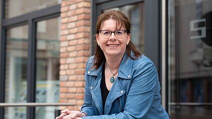 Monika Martens vor einer Fensterfront