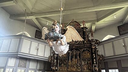 Ein Taufengel schwebt im Altarraum der Kirche