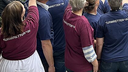 Frauen und Männer mit Turmretter*in-T-Shirts