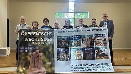 Acht Veranstalter zeigen in der Kirche das Banner der Ökumenischen Woche. 