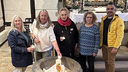 Eine Gruppe aus mehreren Menschen steht in der St. Jürgen Kapelle in Itzehoe und möchten einen Gottesdienst zum Gedenken an verstorbene Kinder feiern.
