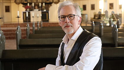 Porträt von Pastor Matthijs van Zwieten de Blom. Er sitzt mitten in der Itzehoer St.-Laurentii-Kirche.