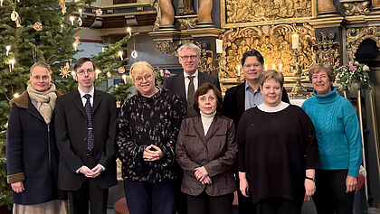 Der achtköpfige Kirchengemeinderat steht vor dem Altar in der St. Nikolaikirche Elmshorn