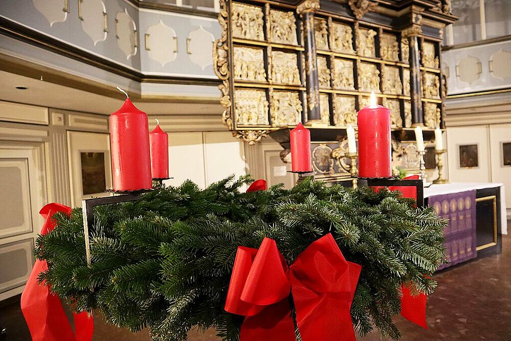 Adventskranz mit angezündeter Kerze in der St. Laurentii Kirche Itzehoe