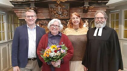Propst Stadtland, Charlotte Israelsen-Kruse, Pastorin Zwirlein und Pastor Petrusch zusammen vor dem Altar nach der Ansgarkreuzverleihung