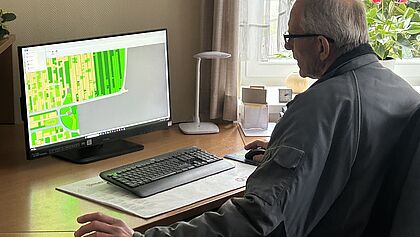 Mann sitzt vor dem Rechner und gibt Einblick in ein Programm
