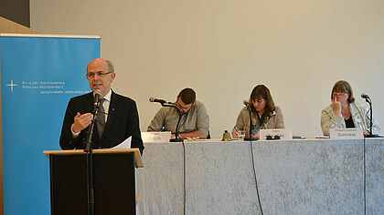 Bischof Magaard am Rednerpult, im Hintergrund das Präsidium mit Florian Frisch, Beate Raudies und Pastorin Gabriele Schinkel