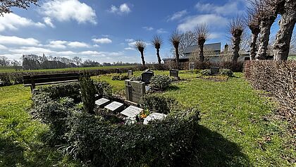 Draufsicht kleinster Friedhof, Familiengrab im Vordergrund, dahinter Rasen