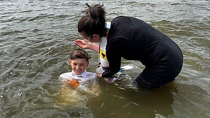 Pastorin Miriam Pietzsch tauft Jungen in der Elbe. 