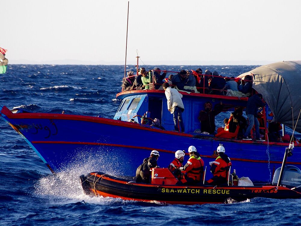 Rettungsboot der Seewatch auf dem Meer neben einem Flüchtlingsboot