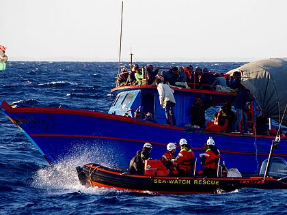 Rettungsboot der Seewatch auf dem Meer neben einem Flüchtlingsboot