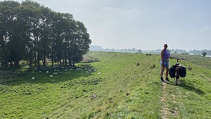 Radfahrerin auf dem grünen Deich