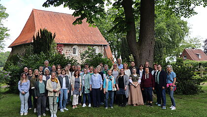 Gruppenfoto Mitarbeitende vor der Kirche auf einer Grünfläche