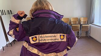 Symbolbild mit der Dienstjacke der Notfallseelsorge von hinten